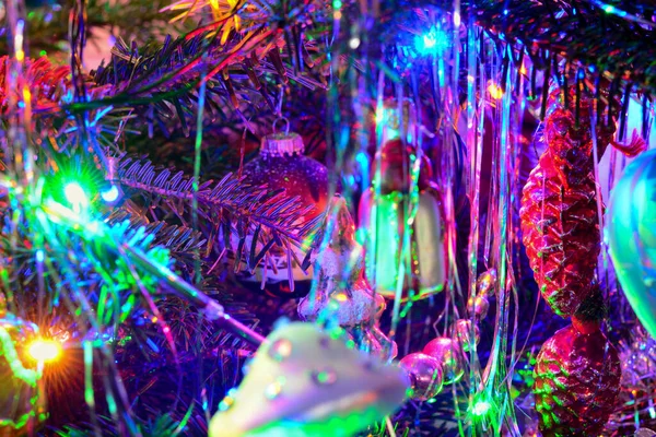 ガーランド、ガラスのおもちゃ、ボール、ライトとクリスマスツリーの休日の背景。ダークキーでカラフルな装飾のクローズアップ. — ストック写真