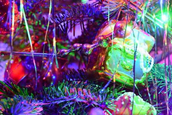 Üvegjátékok a karácsonyfán. Homályos nyaralás háttér koszorú, tinsel, labdák, fények. Színes dekoráció közelkép. — Stock Fotó