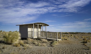 Dinlenme alanı ya da Eyre Gölü 'ndeki umumi tuvaletler parlak mavi gökyüzünün altında kuru ve kurak bir çöl ortamında yer alıyor. Çalı ve kumlu araziyle çevrili