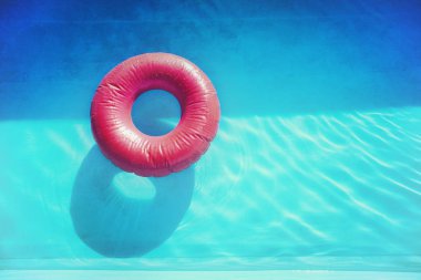 Mavi havuz suyu kırmızı şişme yüzme kemerinde retro tarzı fotoğraf