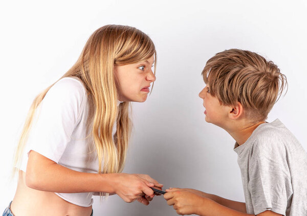 Мальчик и девочка спорят из-за смартфона
