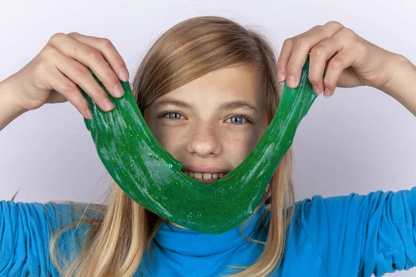 Усміхнена Дівчина Тримає Зелену Іграшку Слизу Перед Обличчям — стокове фото