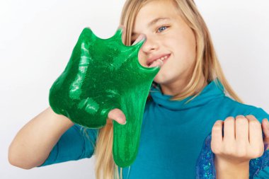 Şeffaf mavi glitter ve yeşil çamur ellerinde tutan kız. Şlamlarına üzerinde duruldu