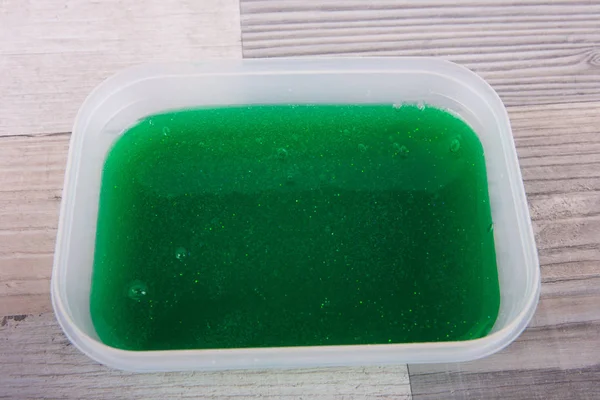 Green slime toy in a plastic box