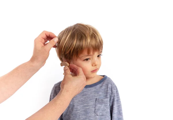 幼児の耳に補聴器を挿入する手 スタジオ撮影 白い背景で隔離 — ストック写真