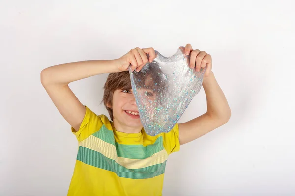 Cheerful Boy Holding Glitter Slime Front Him — Stock Photo, Image