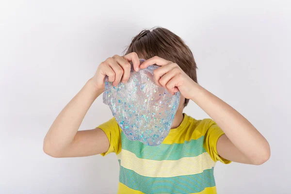 Jonge Jongen Bezit Een Transparante Glitter Slime Voor Zijn Gezicht — Stockfoto