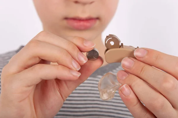 Jonge jongen een hoortoestel batterij vervangen — Stockfoto