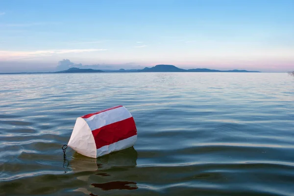 Bóje s červenými a bílými pruhy na modré vody jezera Balato — Stock fotografie