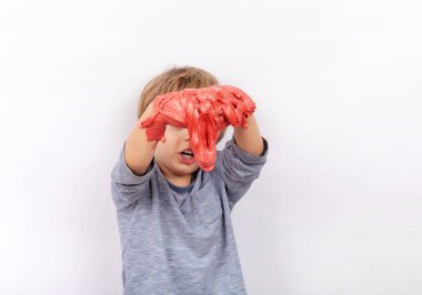 Kırmızı çamur ile oynayan sevimli okul öncesi çocuk