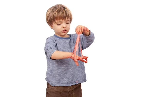 Schattige kleine jongen spelen met slijm ziet eruit als rode smurrie — Stockfoto