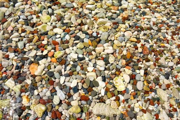 Fargerike småstein i havet som bakgrunn – stockfoto