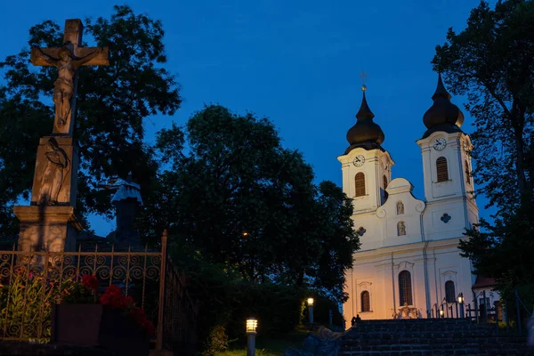 Tihany Abbey at night with a stone cross in the foreground in Hungary — Stock Photo, Image