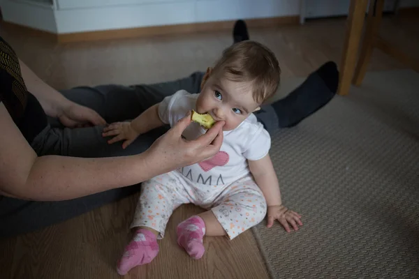 Mão alimentando uma maçã bebê — Fotografia de Stock