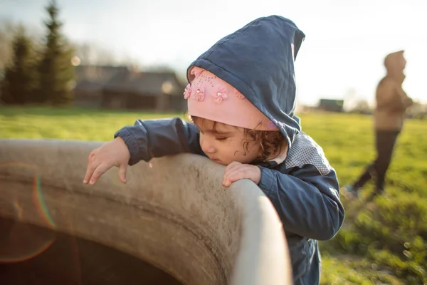 Little child near the pool in the street in the spring — Stock Photo, Image