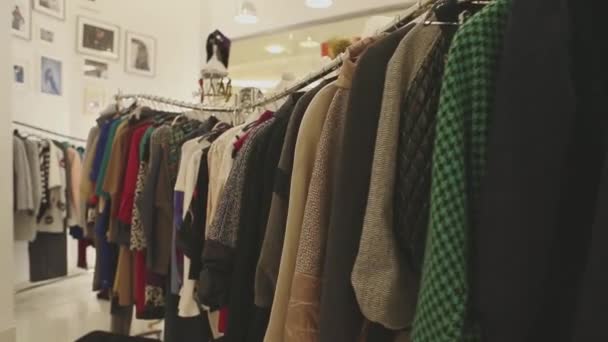 Ropa de diseñador de moda en perchas en la tienda — Vídeo de stock