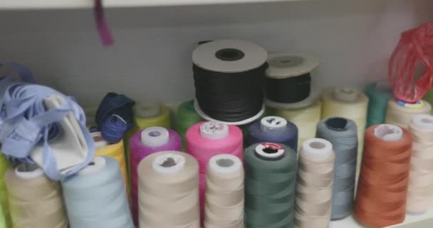 Spools berwarna-warni dari thread dan aksesoris pekerjaan menjahit lainnya — Stok Video