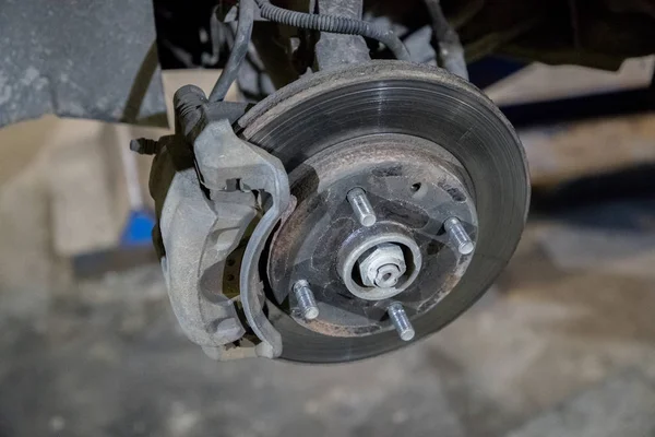 Старий і іржавий гальмівний диск автомобіля під ремонтом в гаражі — стокове фото