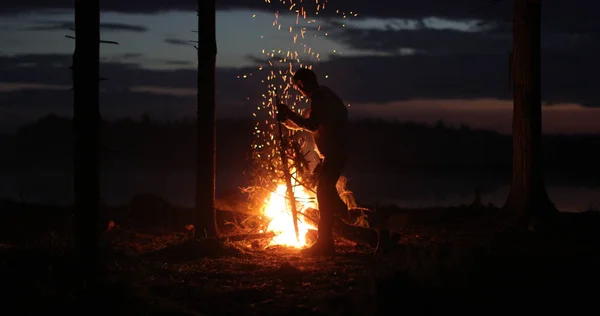 Silhueta de um homem perto do fogo à noite contra o céu — Fotografia de Stock