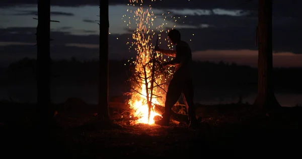 Silhuett av en man nära elden på natten mot himlen — Stockfoto