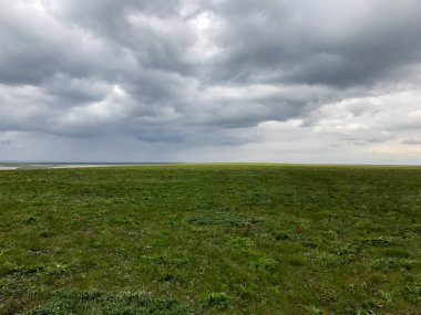 büyük yeşil alan ve beyaz bulutlar ile bir gökyüzü