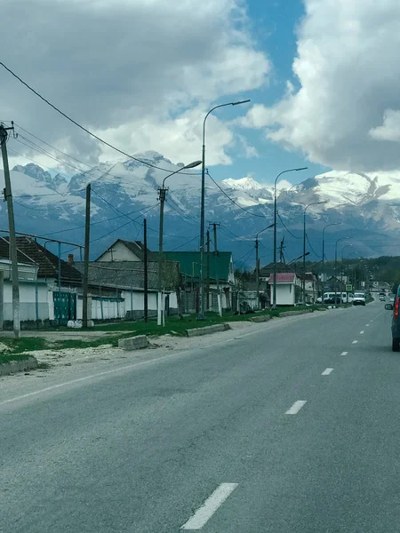 Snelweg aan de linkerkant van het huis en de bergen, evenals de hemel met witte wolken — Stockfoto