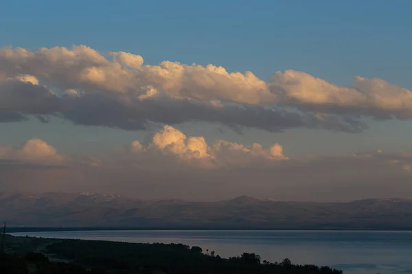 Paisaje nocturno del mar sobre el telón de fondo de montañas y nubes — Foto de Stock