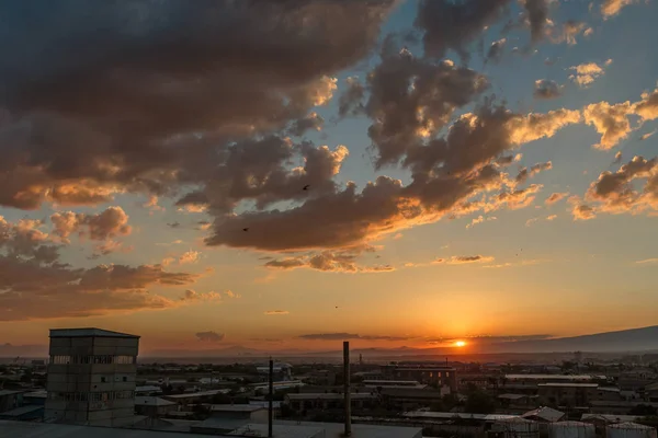 Photo of the sunset and clouds as well as the infrastructure of the small town — Stock Photo, Image