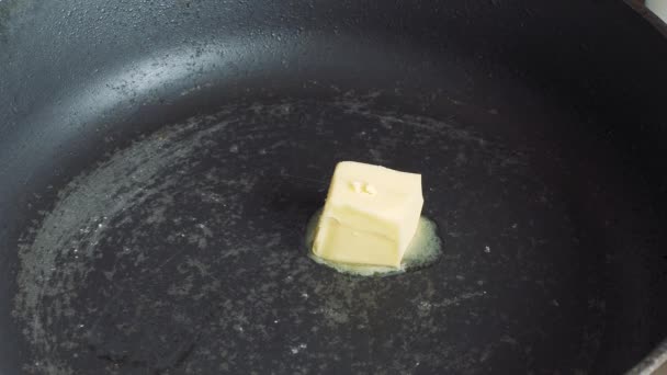 Масло тает в горячей сковороде — стоковое видео
