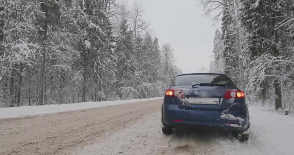 Gebroken auto aan de kant van de weg in winter bos — Stockvideo