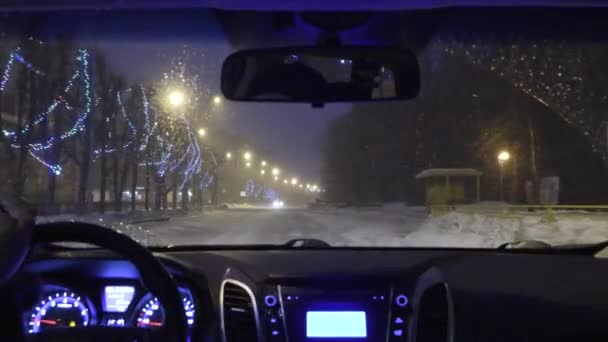 Rijden in een auto in de nacht stad in de winter. uitzicht vanuit de cabine — Stockvideo