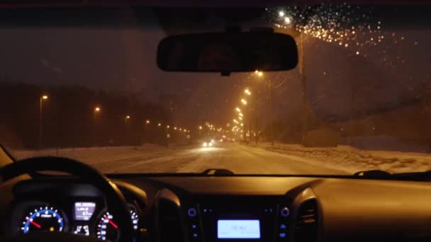 Rijden in een auto in de nacht stad in de winter. uitzicht vanuit de cabine — Stockvideo