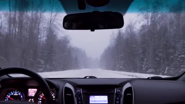 Dirigir um carro em uma estrada de inverno durante uma tempestade de neve — Vídeo de Stock