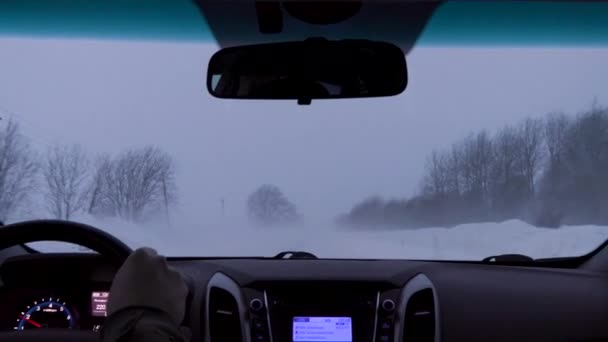 Вождение автомобиля на зимней сельской дороге во время снежной бури — стоковое видео