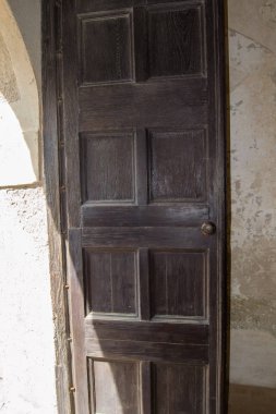 Tahta kapı güneşin battığı eve açılıyor.