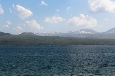dağlar ve beyaz bulutlar bir arka plan karşı denizden manzara