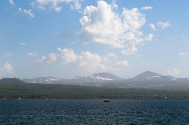 dağlar ve beyaz bulutlar bir arka plan karşı denizden manzara