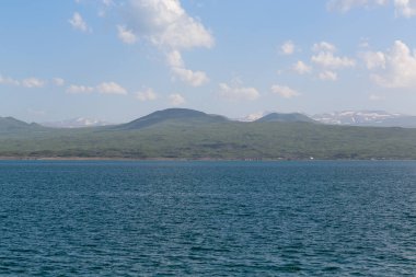 dağlar ve beyaz bulutlar bir arka plan karşı denizden manzara