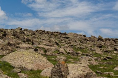aşağıdan beyaz bulutların bir arka plan üzerinde taş tepe görünümü