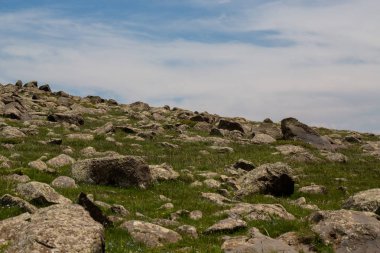 aşağıdan beyaz bulutların bir arka plan üzerinde taş tepe görünümü
