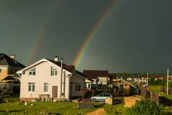 Rainbow against the backdrop of a small house in the village — Stock Photo, Image