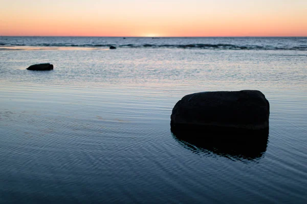 Pôr do sol no mar calmo com pedras — Fotografia de Stock