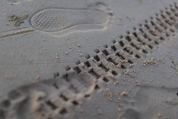 Kum üzerinde bir motosiklet bir mans ayakkabı ve lastiklerin parça — Stok fotoğraf