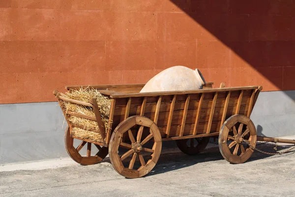 Carro de madera con una jarra grande en el interior — Foto de Stock