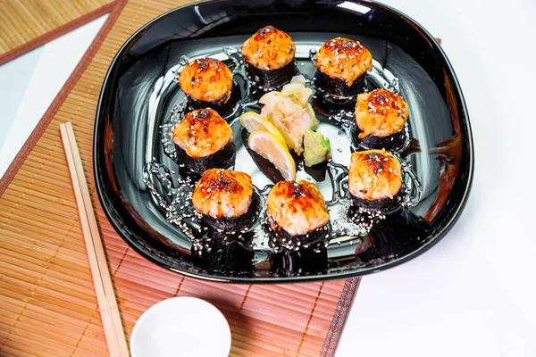 Foto van gebakken Japanse broodjes in een zwarte plaat — Stockfoto