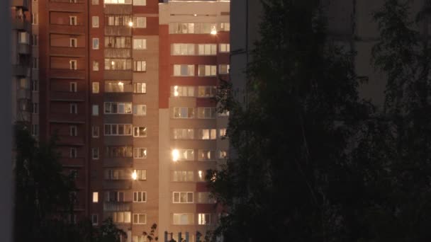 Sol puesta del sol se refleja en las ventanas de un edificio de varios pisos — Vídeos de Stock