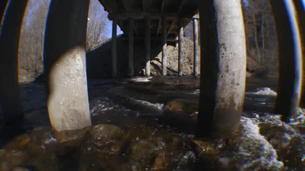Ροή ποταμών κάτω από μια ενισχυμένη γέφυρα σκυροδέματος την άνοιξη — Αρχείο Βίντεο