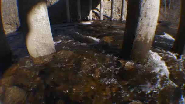 Поток реки под железобетонным мостом весной — стоковое видео