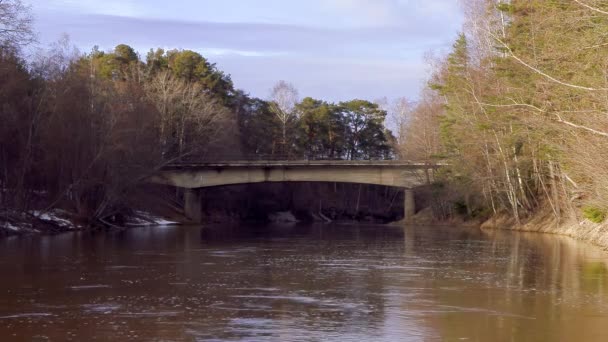 Pont routier en béton traversant la rivière un jour de printemps — Video