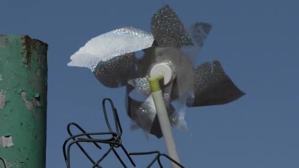 Windmill toy reluctantly spinning in the wind — Stock Video